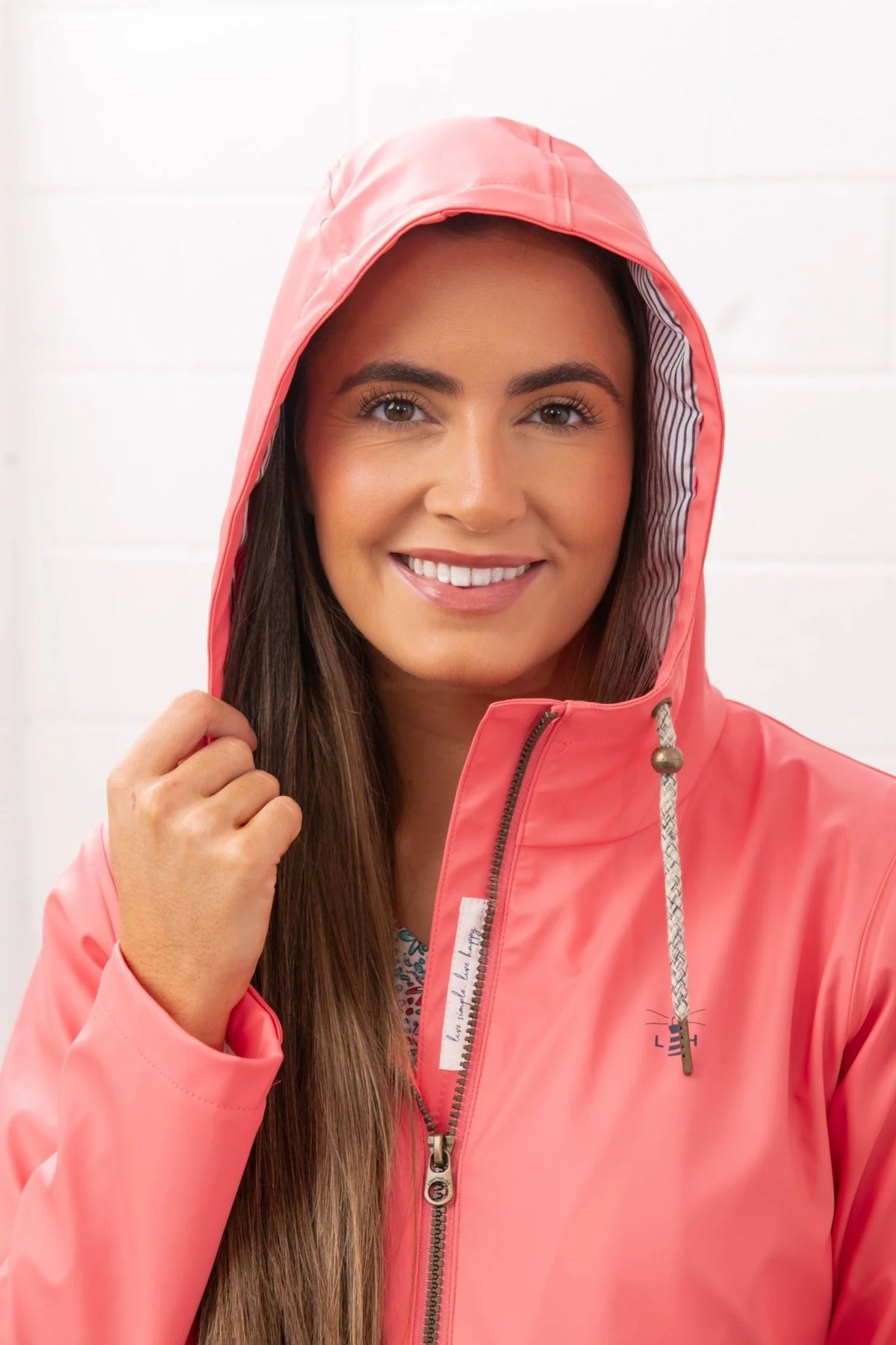 Lighthouse womens coral jacket with hood and zipper worn by smiling woman