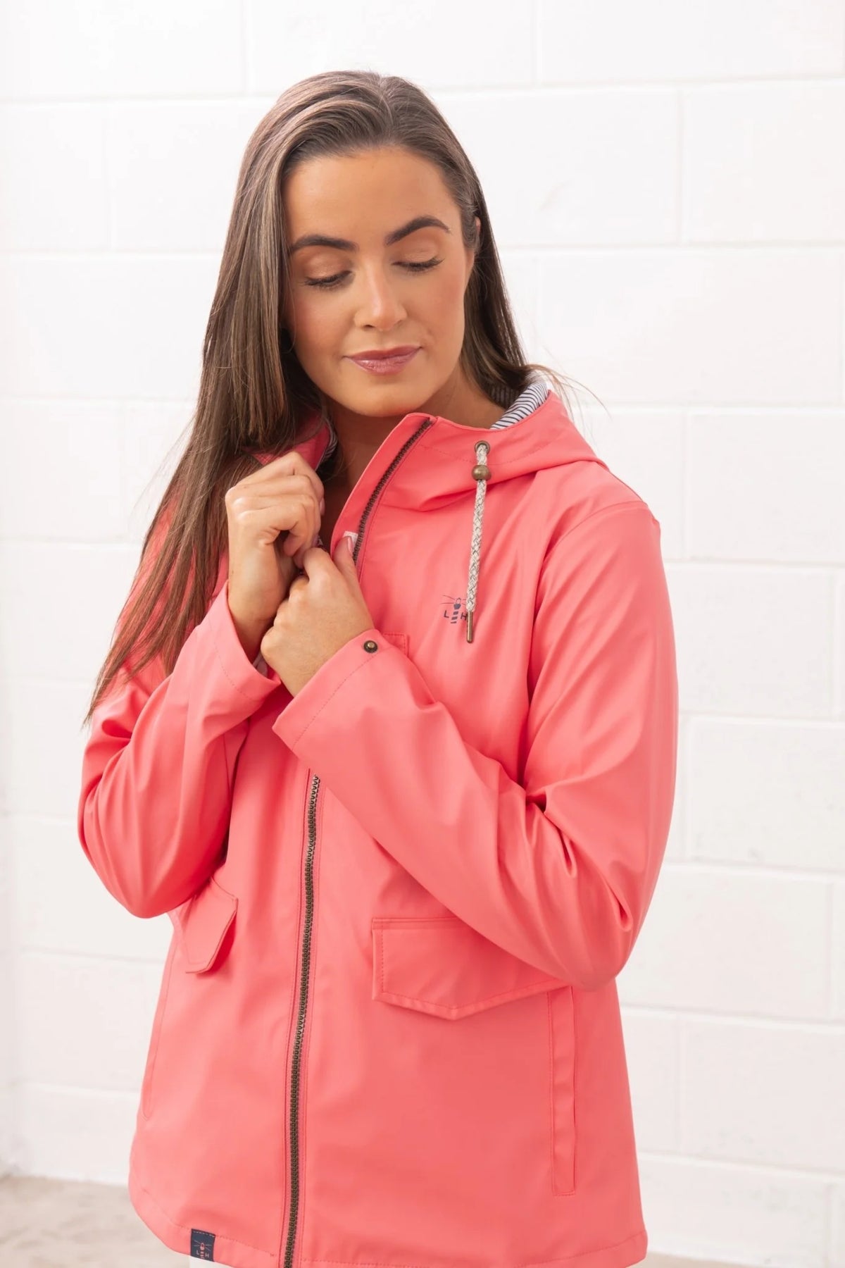 Lighthouse womens coral jacket with hood and front pockets worn by a woman