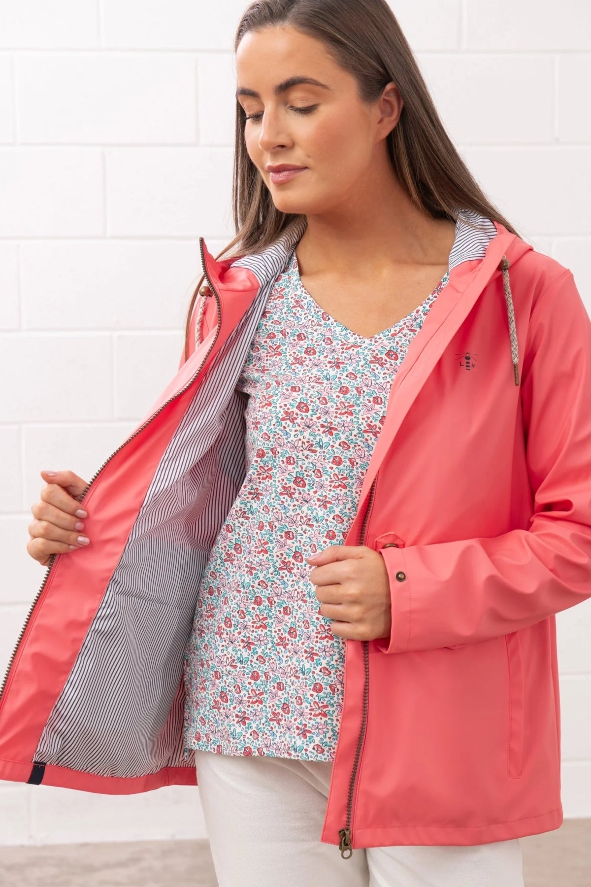 Lighthouse womens coral jacket open showing striped lining worn over floral top with white pants