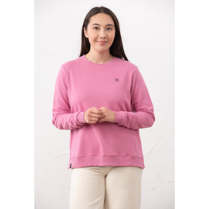 Front view of a woman wearing a Lighthouse Seaside crew neck sweatshirt in Pink.