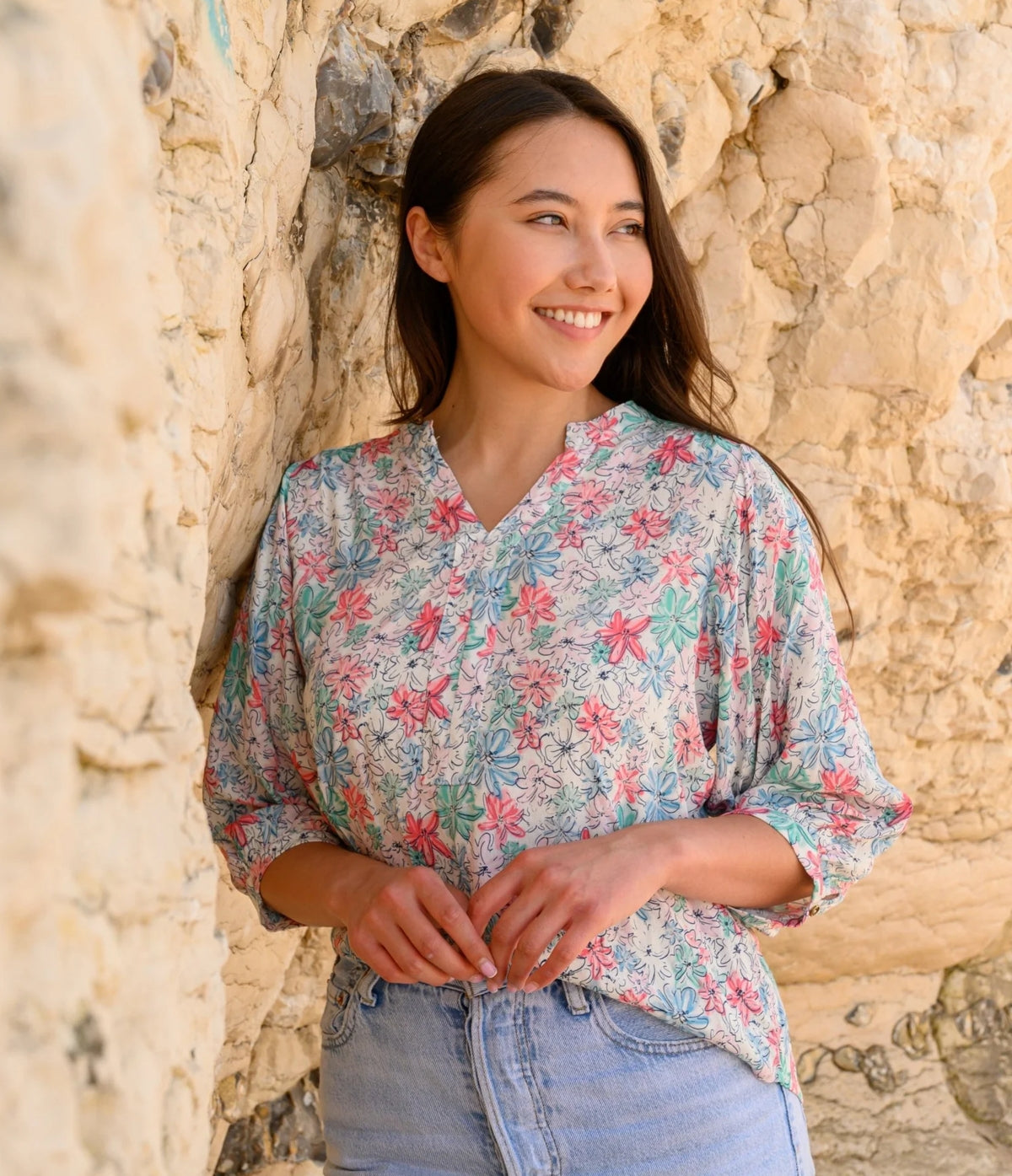 Lighthouse womens Lola floral blouse with pink and green flowers worn by a smiling woman outdoors