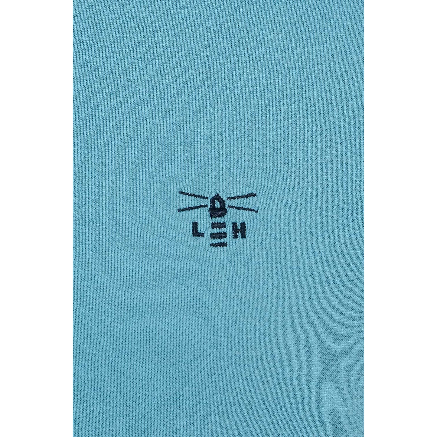 Close-up view of the embroidered logo of a Lighthouse women's Seaside crew neck sweatshirt in blue.