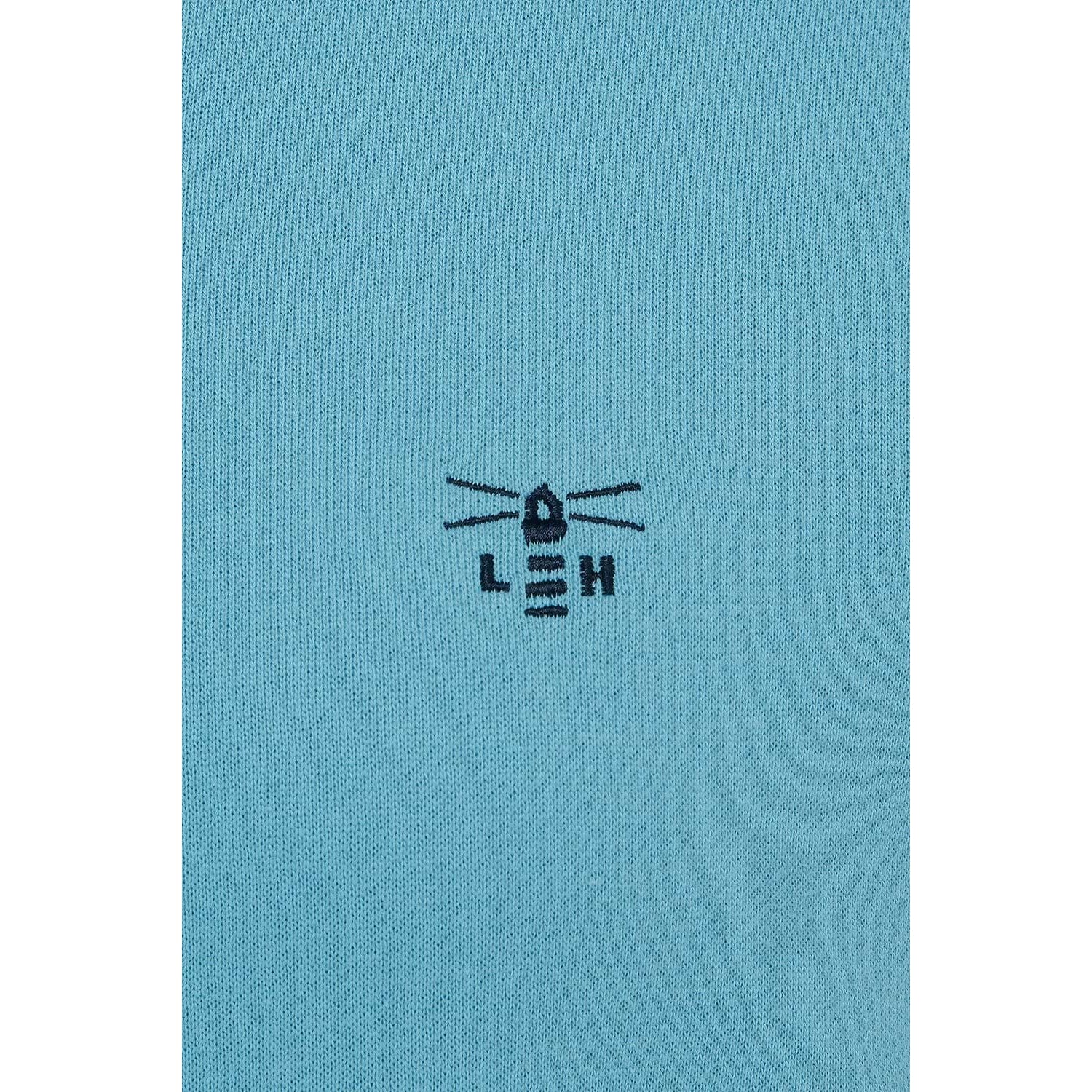 Close-up view of the embroidered logo of a Lighthouse women's Seaside crew neck sweatshirt in blue.