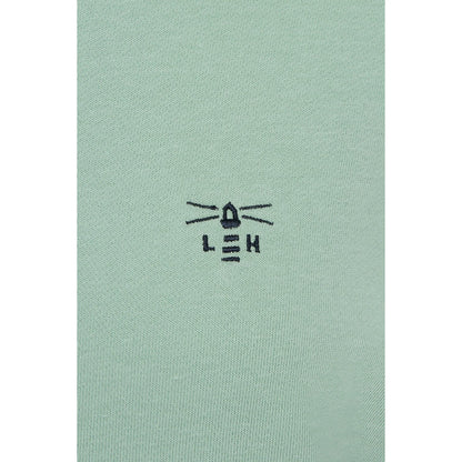 Close-up view of the embroidered logo of a Lighthouse women's Seaside crew neck sweatshirt in Pastel Green.
