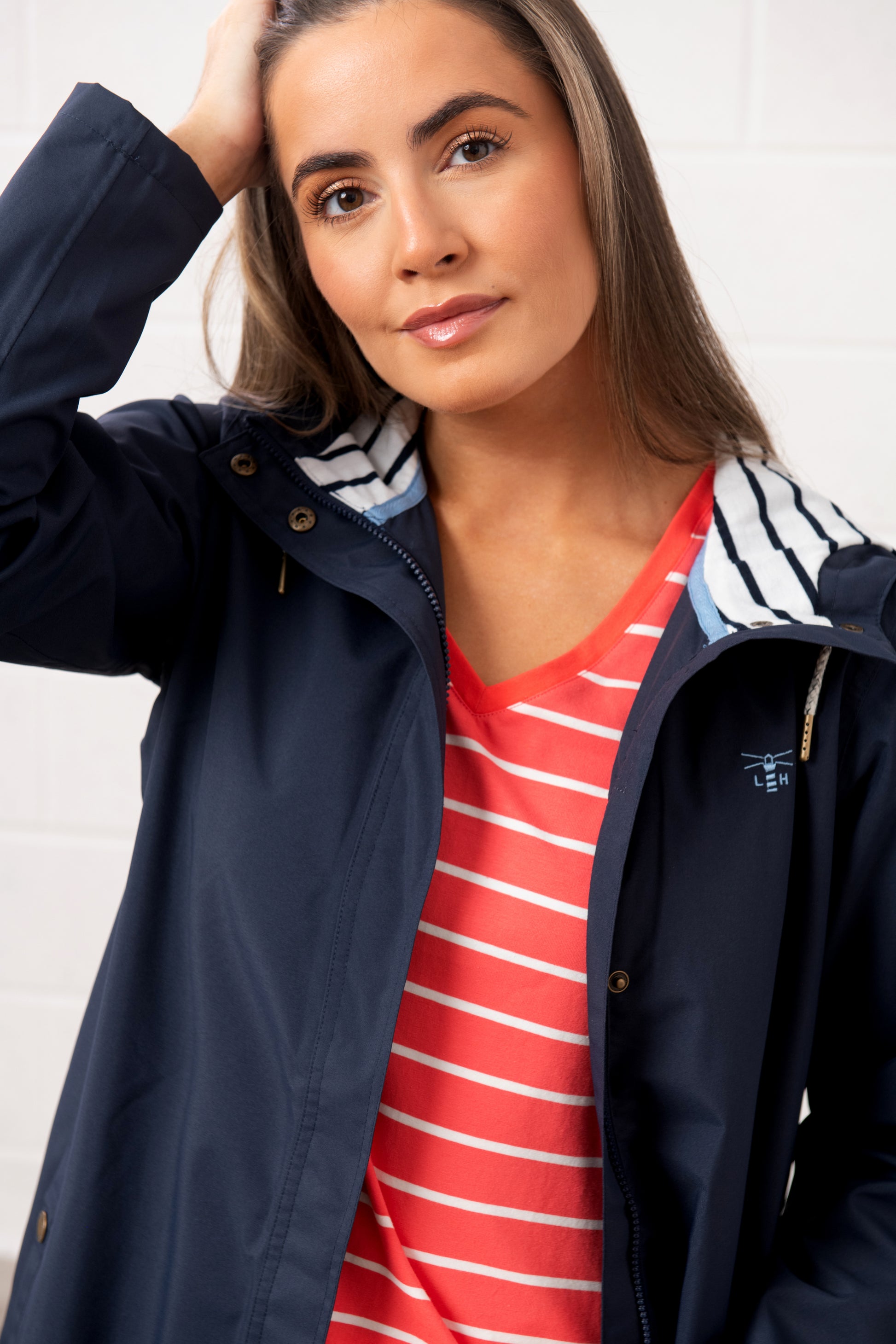 Lighthouse womens navy waterproof jacket with striped hood worn over red striped shirt