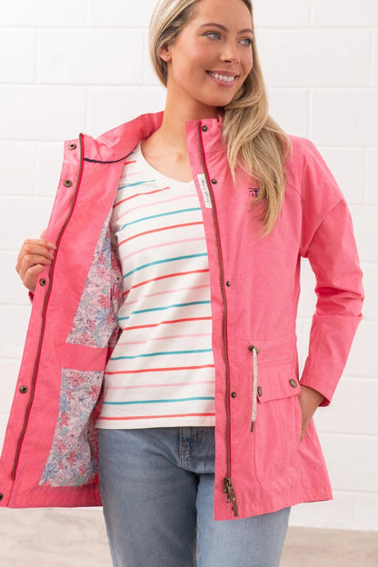 Lighthouse womens pink waterproof jacket open to show floral inner lining worn with striped shirt and jeans