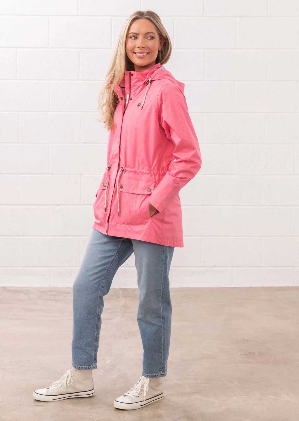 Lighthouse womens pink waterproof jacket worn by model with hood and front pockets