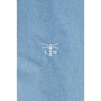 Close-up view of the logo on a Lighthouse Pippa coat in white on a Soft Denim Blue waterproof fabric.