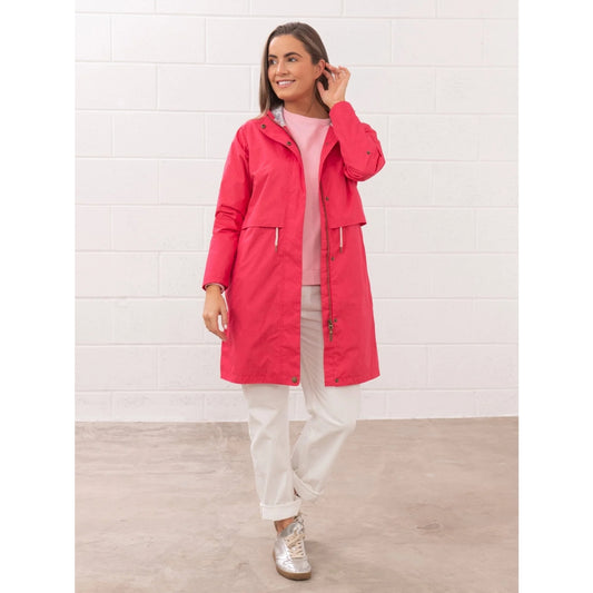 Front view of a woman wearing a Lighthouse Pippa 3/4 length waterproof raincoat in Raspberry pink/red.