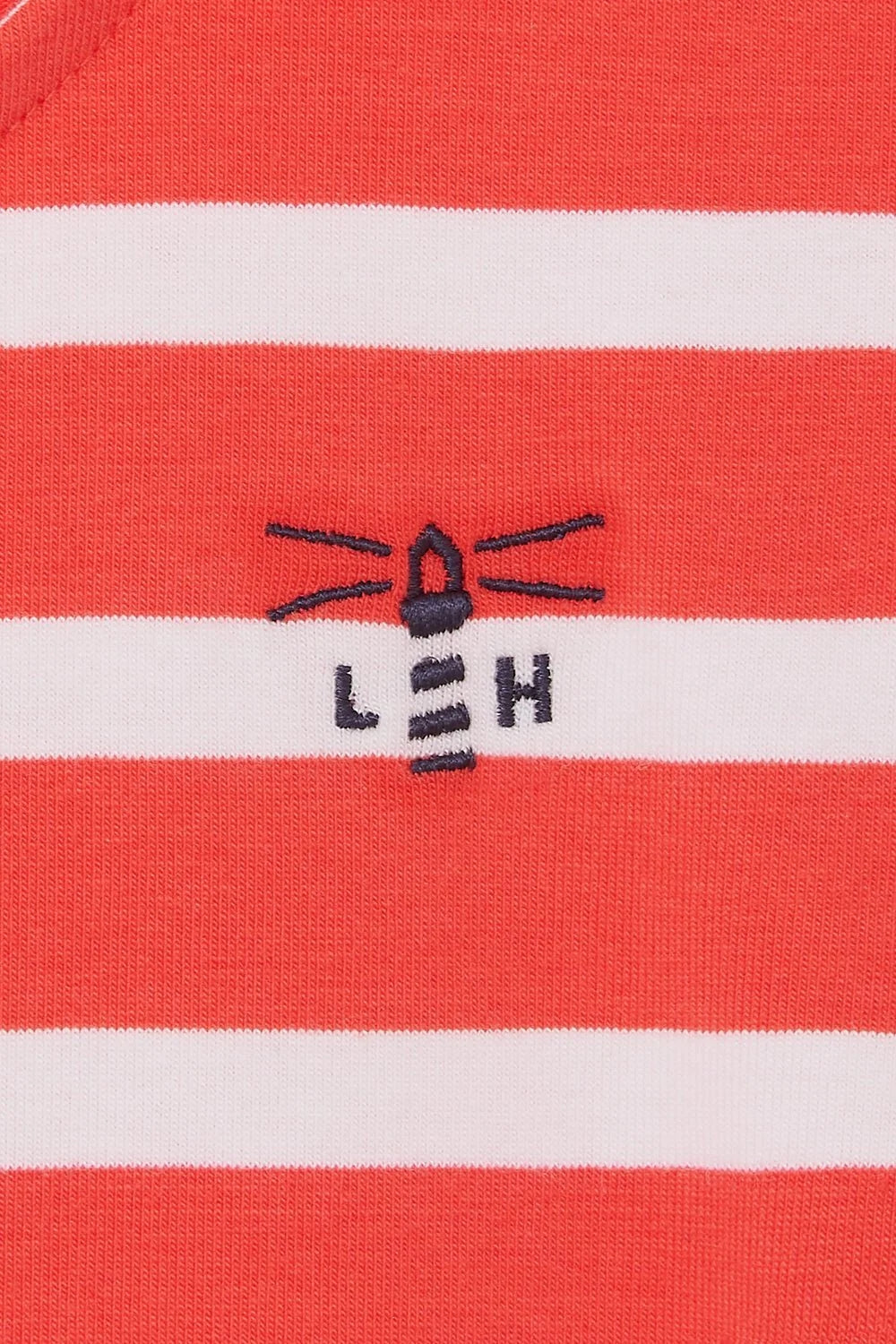 Close-up of Lighthouse womens red stripe dress fabric with embroidered lighthouse logo