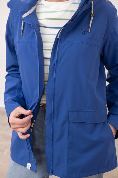 Lighthouse womens waterproof jacket in blue with hood and front pockets worn over striped shirt
