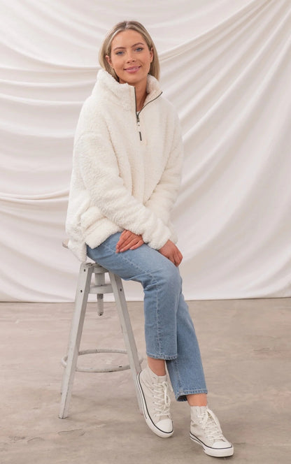 Lighthouse womens zip fleece in white worn by model sitting on stool with casual jeans and sneakers