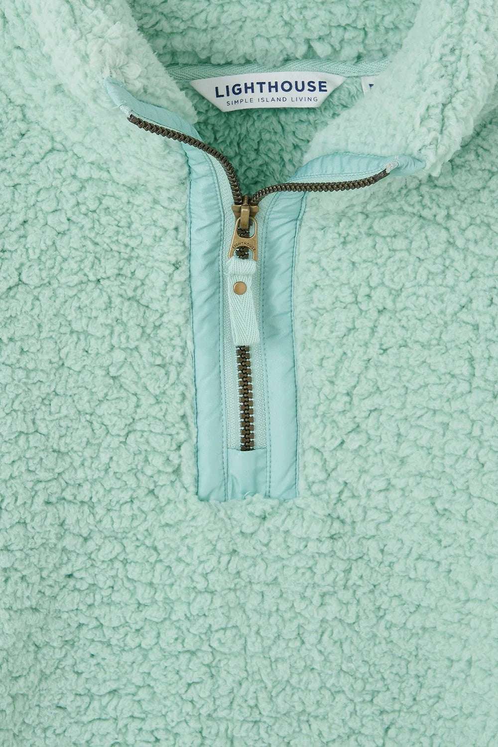 Close-up of Lighthouse womens zip neck fleece in light mint green with textured fabric and zipper detail