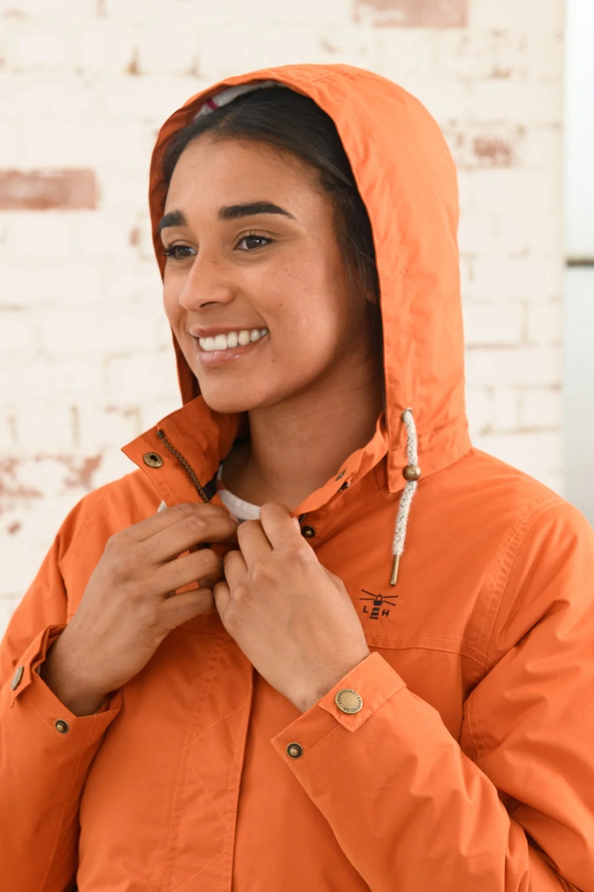 Women's hooded waterproof Eva rain coat from Lighthouse in Burnt Orange.