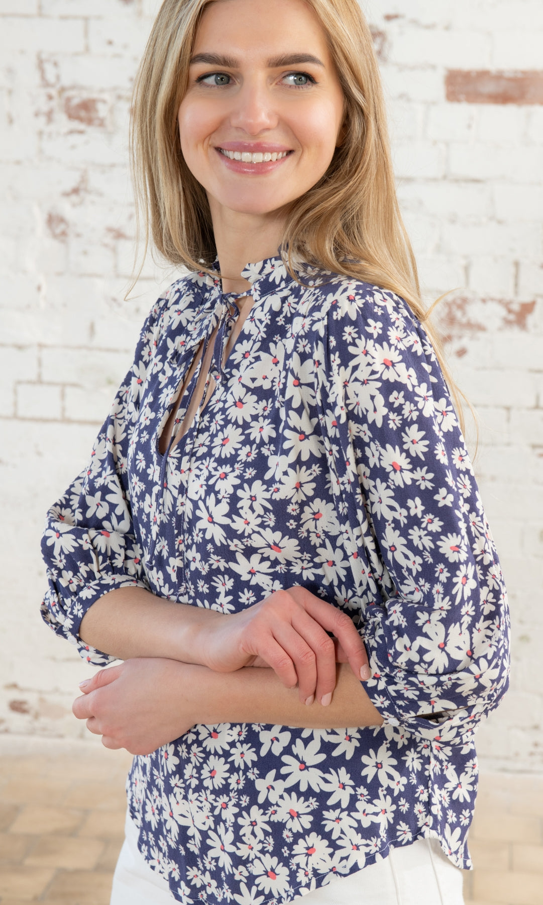 Lighthouse women's tie neck Lola blouse in indigo blue with a white and yellow floral daisy pattern.