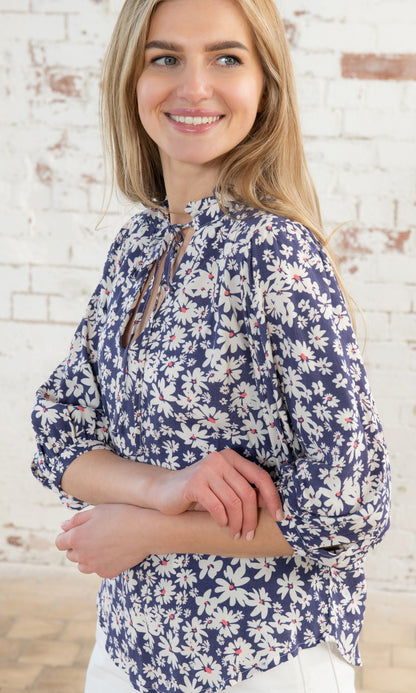 Lighthouse women's tie neck Lola blouse in indigo blue with a white and yellow floral daisy pattern.