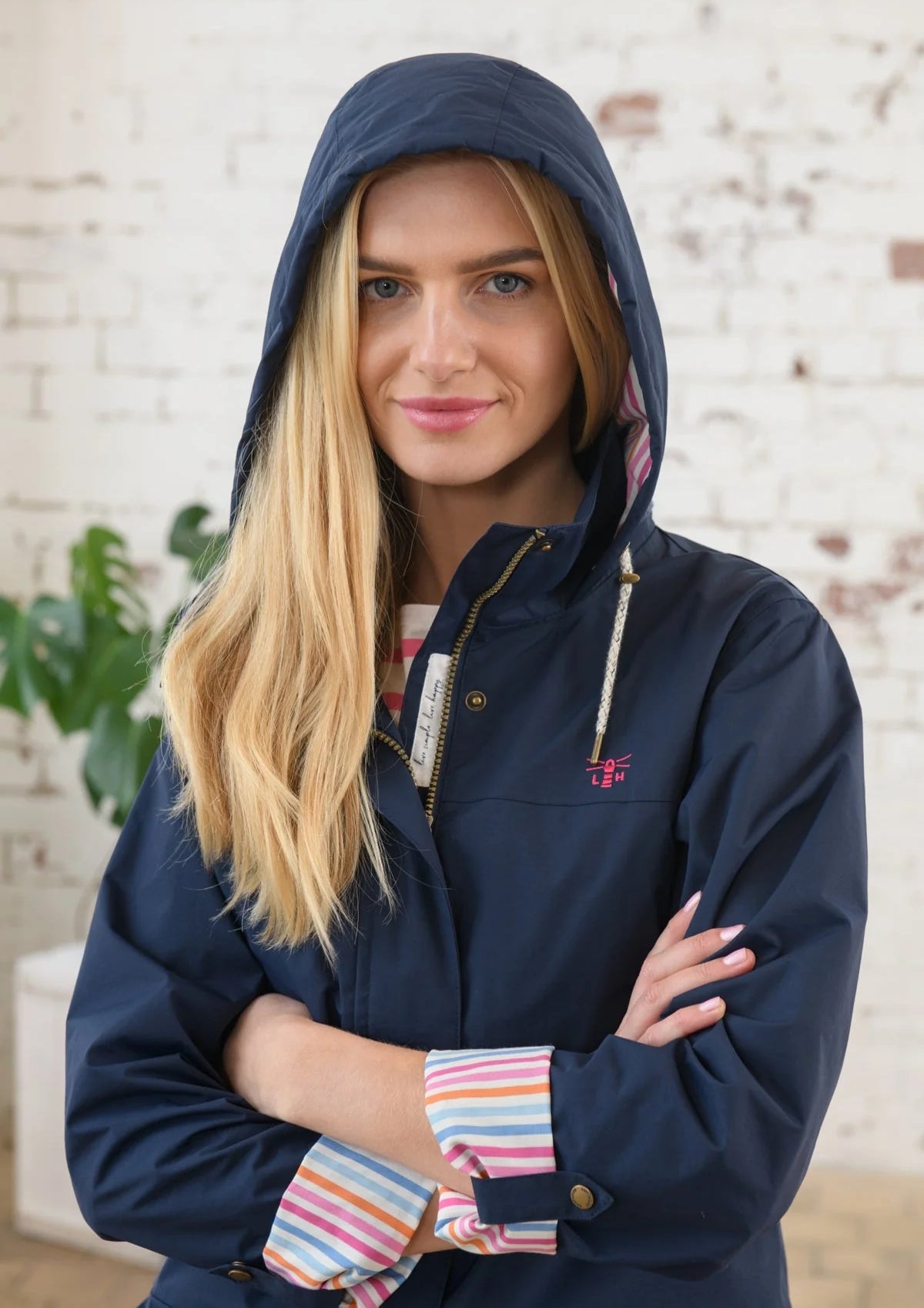 Women's Navy Rebecca hip length waterproof rain jacket from Lighthouse with turn back cuffs.