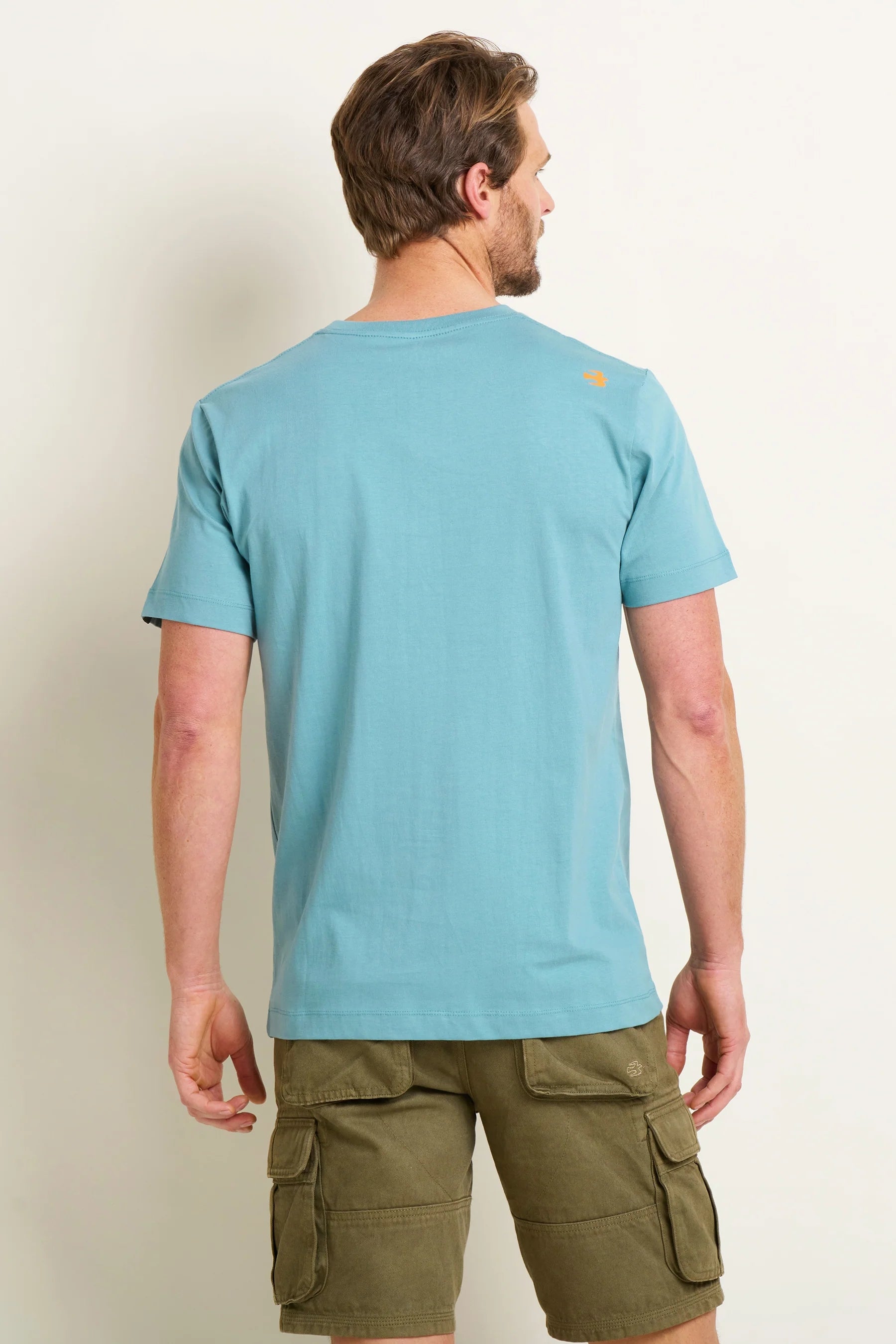 Back view of mens Brakeburn paddleboard tee blue worn by a man with olive cargo shorts