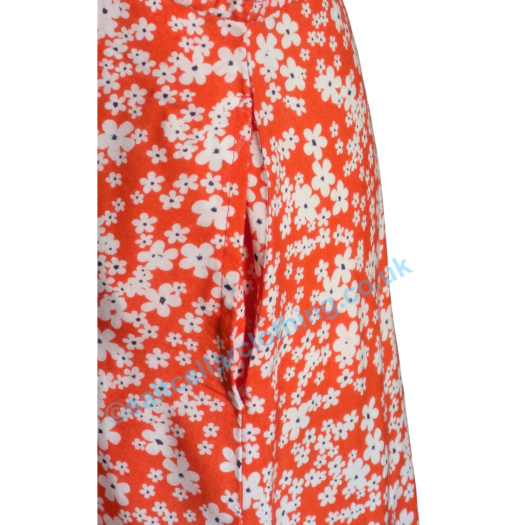 Close up of the pocket on a womens Mudd & Water Alyssa dress in coral with a floral print on a white background.