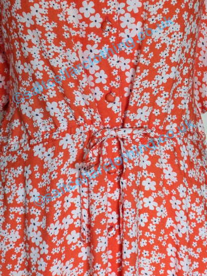 Close up of the button up, tie front of a Mudd & Water womens Alyssa dress in coral with a floral pattern
