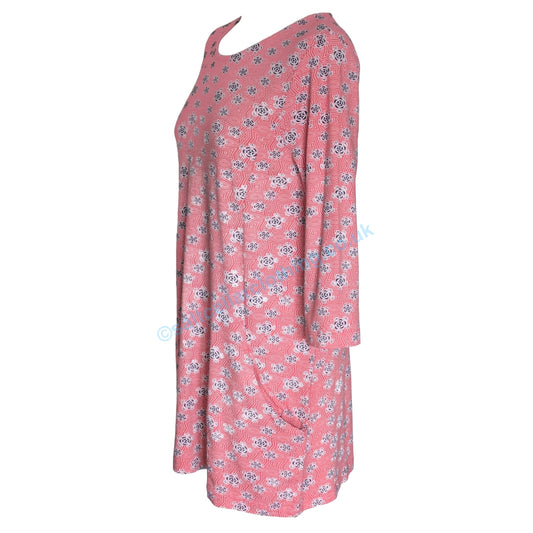 Side view of a womens Mudd and Water Francoise tunic in coral with a geo floral pattern, 3/4 length sleeves and hip pockets on a white background