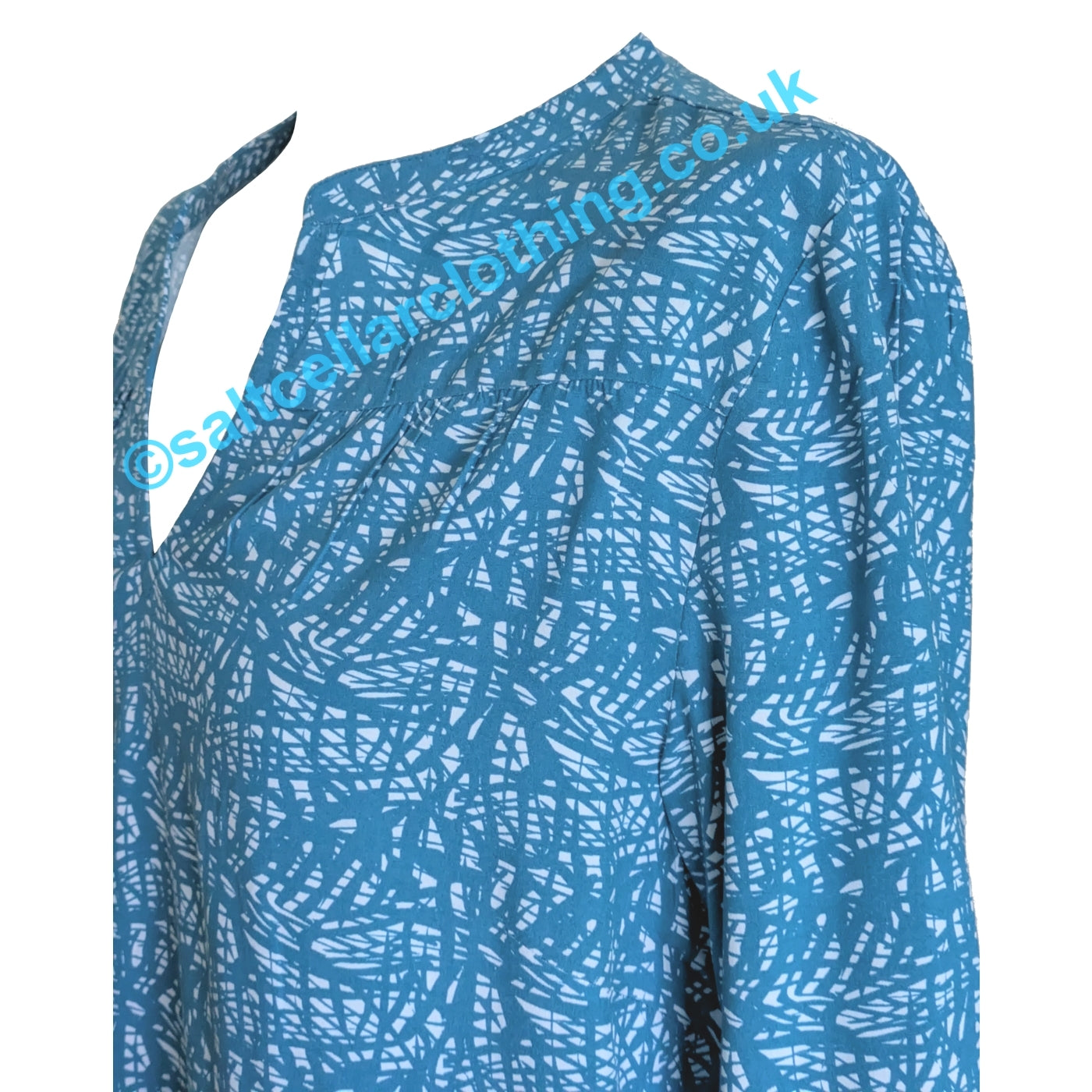 Close up of the mandarin neckline of a Mudd & Water womens Bailey blouse in teal blue with abstract white pattern