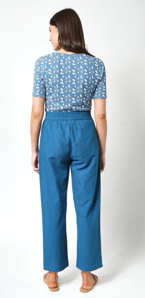 Back view of woman wearing Mudd and Water womens blue print top paired with blue high-waisted pants