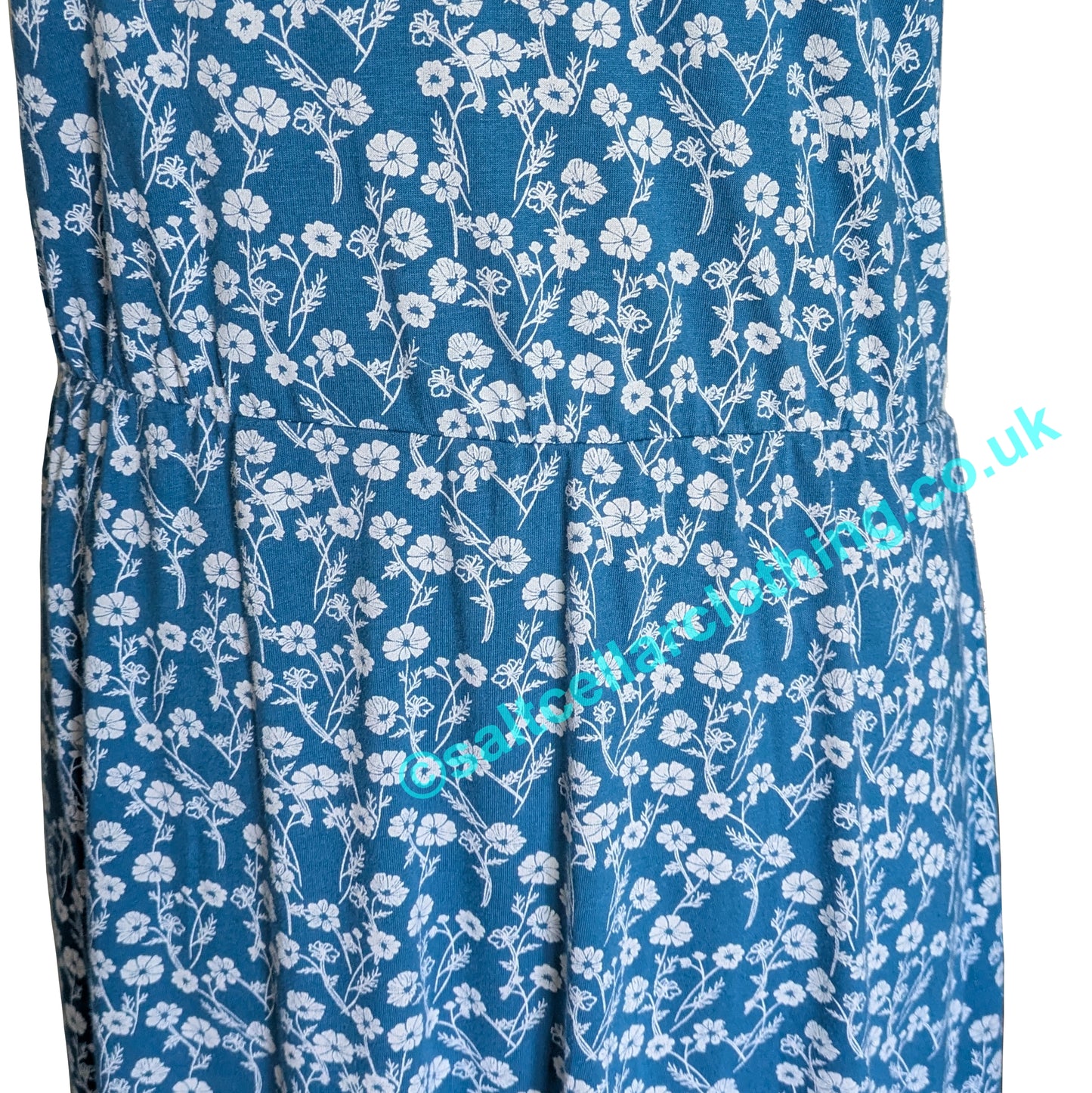 Close up of an elasticated waist of a Mud & Water Iris dress in Teal blue with white floral pattern fabric, on a white background.