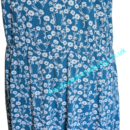 Close up of an elasticated waist of a Mud & Water Iris dress in Teal blue with white floral pattern fabric, on a white background.