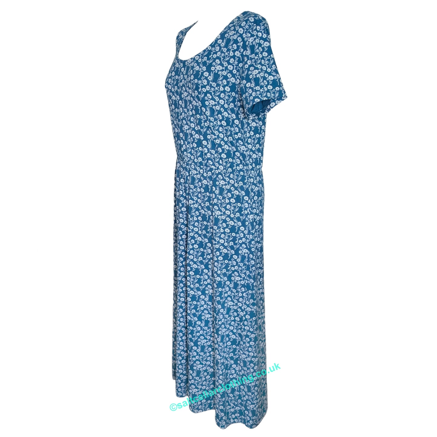 Side view of a womens scoop neck Mudd & Water short sleeve Iris Dress in Teal blue with a white floral print on a white background