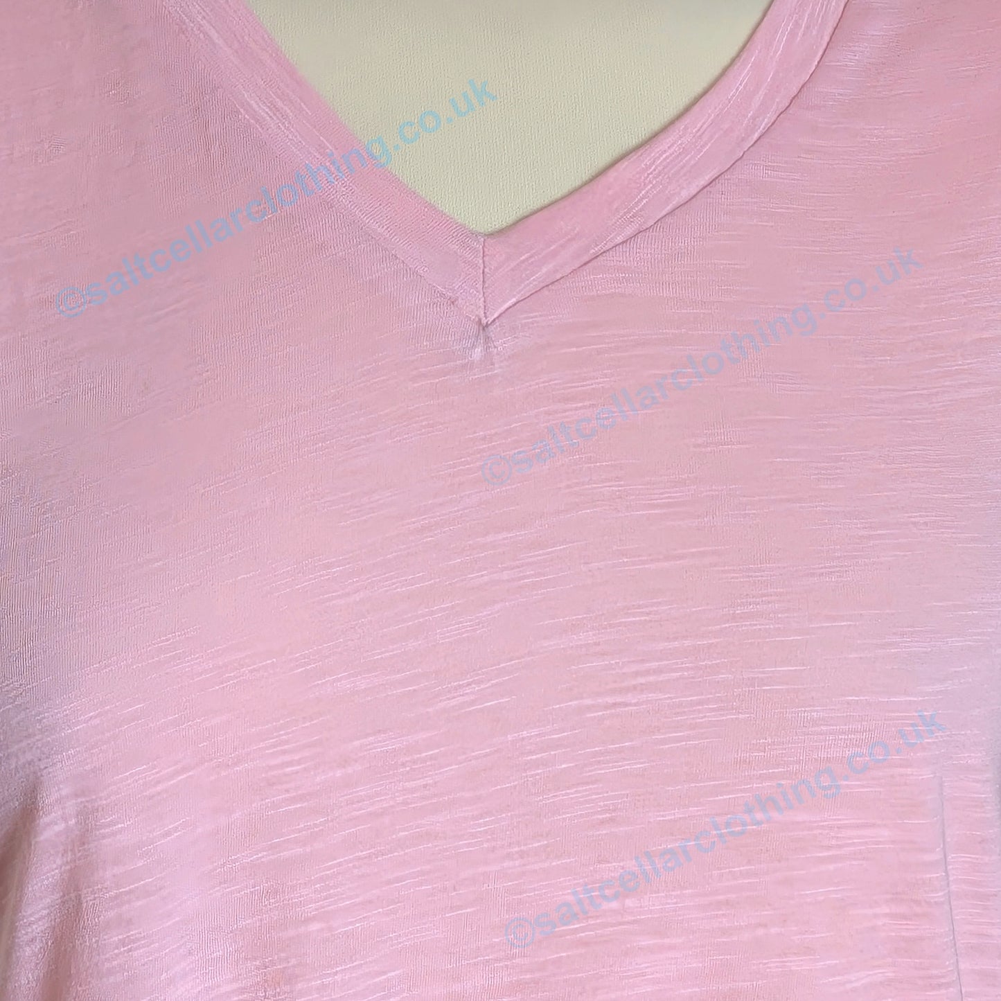 Close-up view of the v-neckline of a womens Mudd and Water Rozela vest in Candy Pink