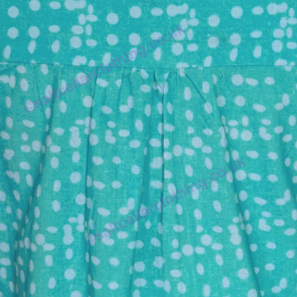 Close-up of a Mudd & Water Sunrise Blouse turquoise fabric with polka dot pattern and pleats