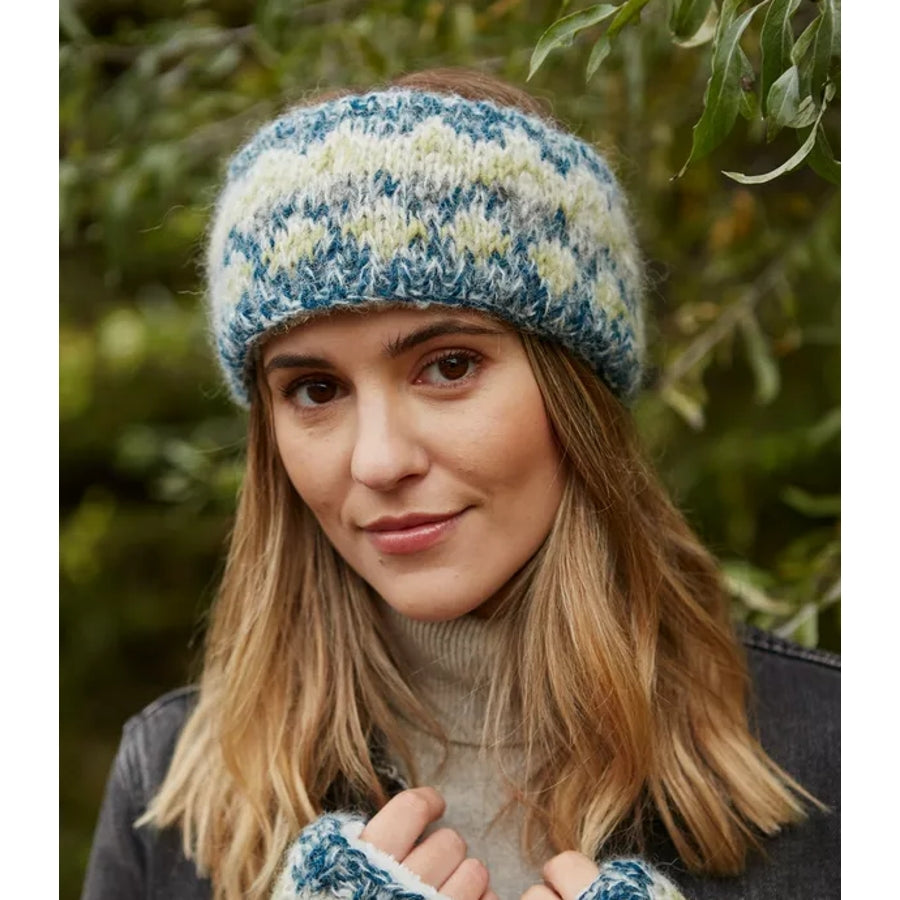 Woman wearing a Pachamama Totnes Spruce Green and white knitted headband with a natural background