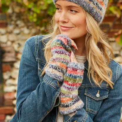 Woman wearing Pachamama Coroico colourful striped handwarmers and a patterned hat outdoors.