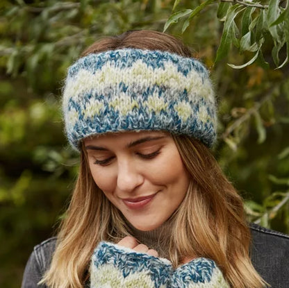 Woman wearing a green and white striped knitted Pachamama headband outdoors.