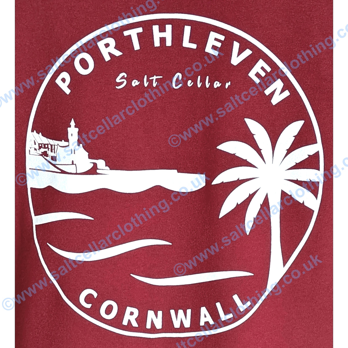A close-up view of the back print of a unisex red popover hoodie, featuring a large white circular graphic with the text 'PORTHLEVEN' 'Salt Cellar' and 'CORNWALL' with the Porthleven harbour and clocktower, waves and a palm tree illustration.