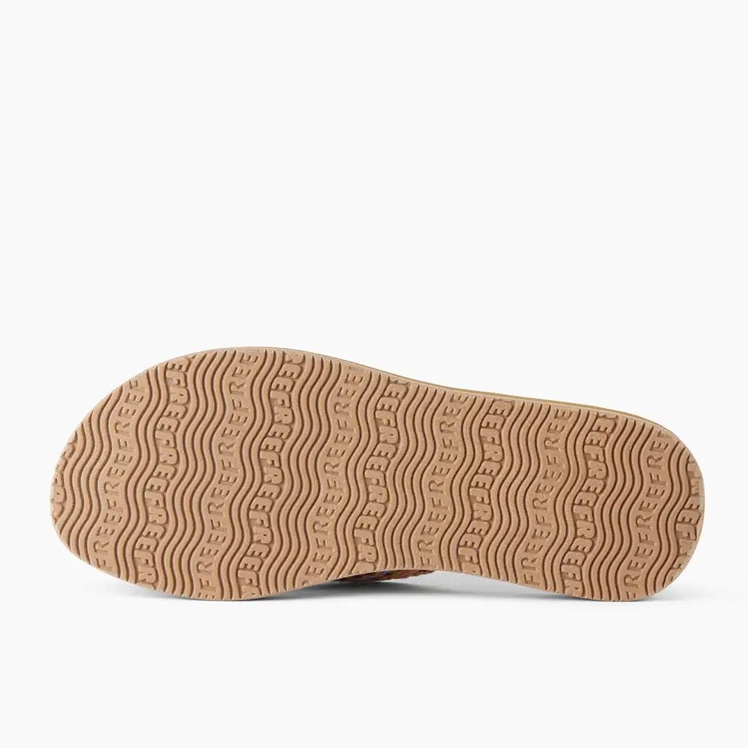 Bottom sole view of womens Reef Baja Elana flip flops in Brown/Pink with Reef logo and wave shape outsole grips.