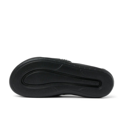 Bottom sole view of a mens Reef Tailslide slider sandal in black with a padded strap.