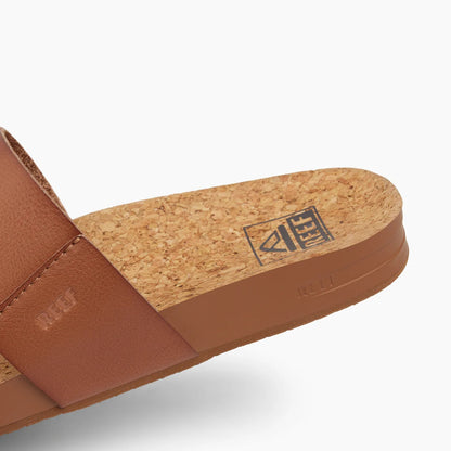 Close-up view of the back of a womens Reef Cushion Vista faux leather double strap sandal in Espresso Duo brown, with cork footbed and printed logo.