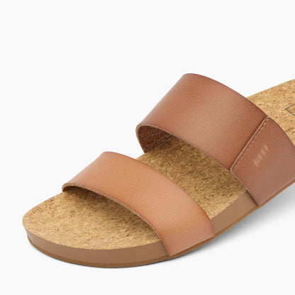 Close-up view of the front of a womens Reef Cushion Vista faux leather double strap sandal in Espresso Duo brown, with cork footbed.