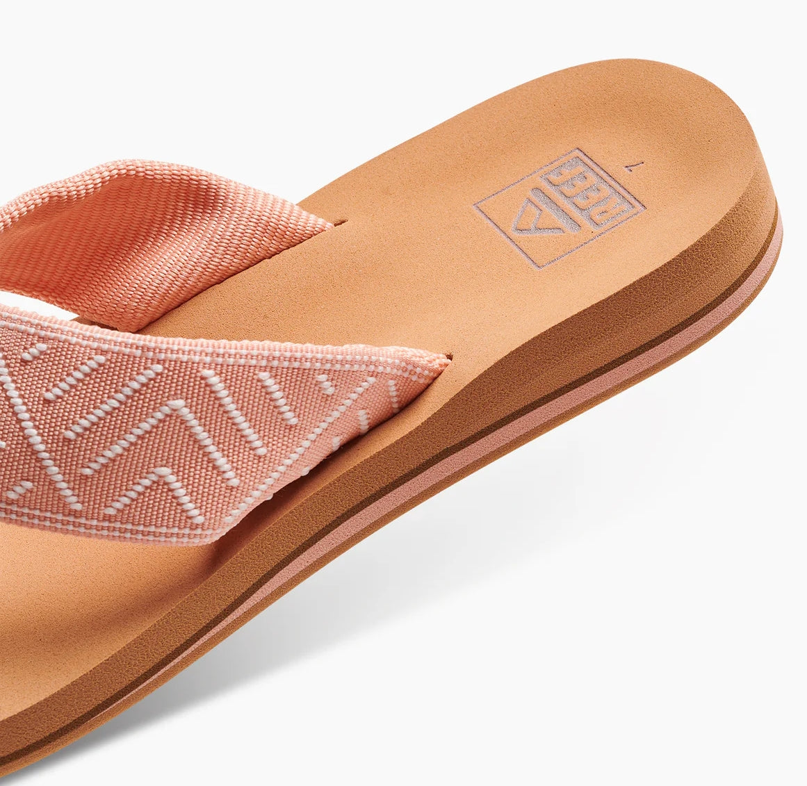Reef womens peach flip flops with cushioned sole and textured fabric straps for comfortable wear