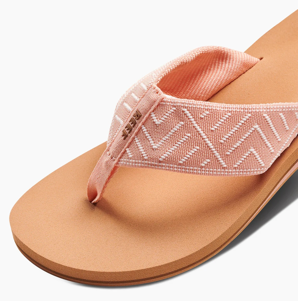 Reef womens peach flip flops with textured fabric straps and cushioned tan sole