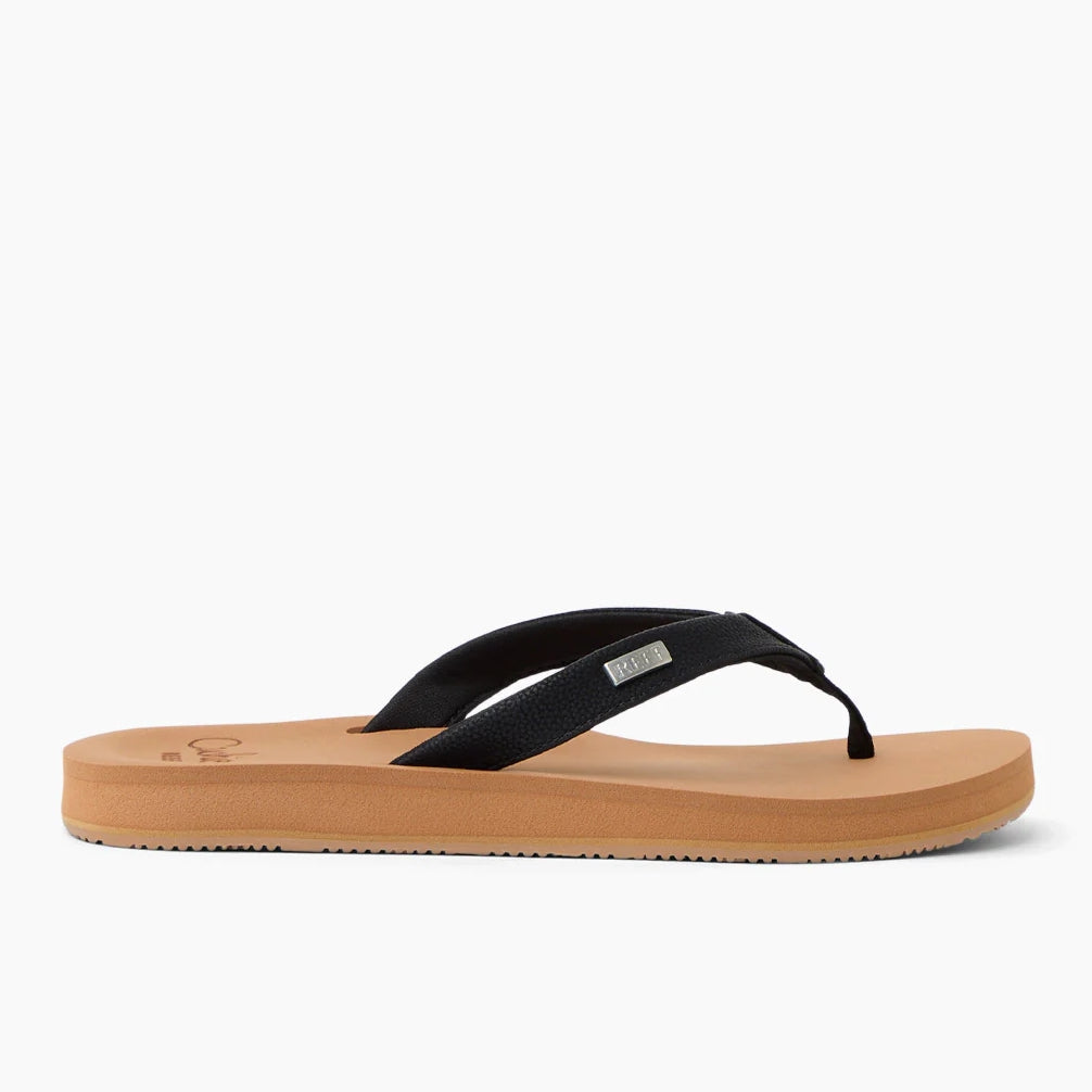 Side view of womens Reef Baja Sands flip flops with a tan sole, black strap with metal logo