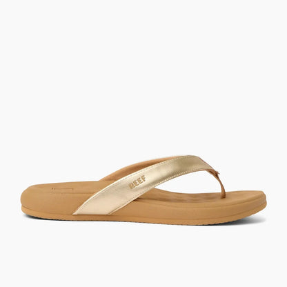 Side view of women's Reef Cushion Melody flip flops with a Champage Gold strap and pillow textured cushioning footbed.