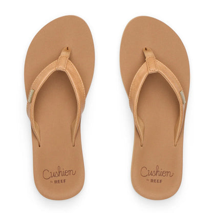 Top view of womens Reef Baja Sands flip flops in Almond brown with gold logo label on the strap and cushion sole branding.