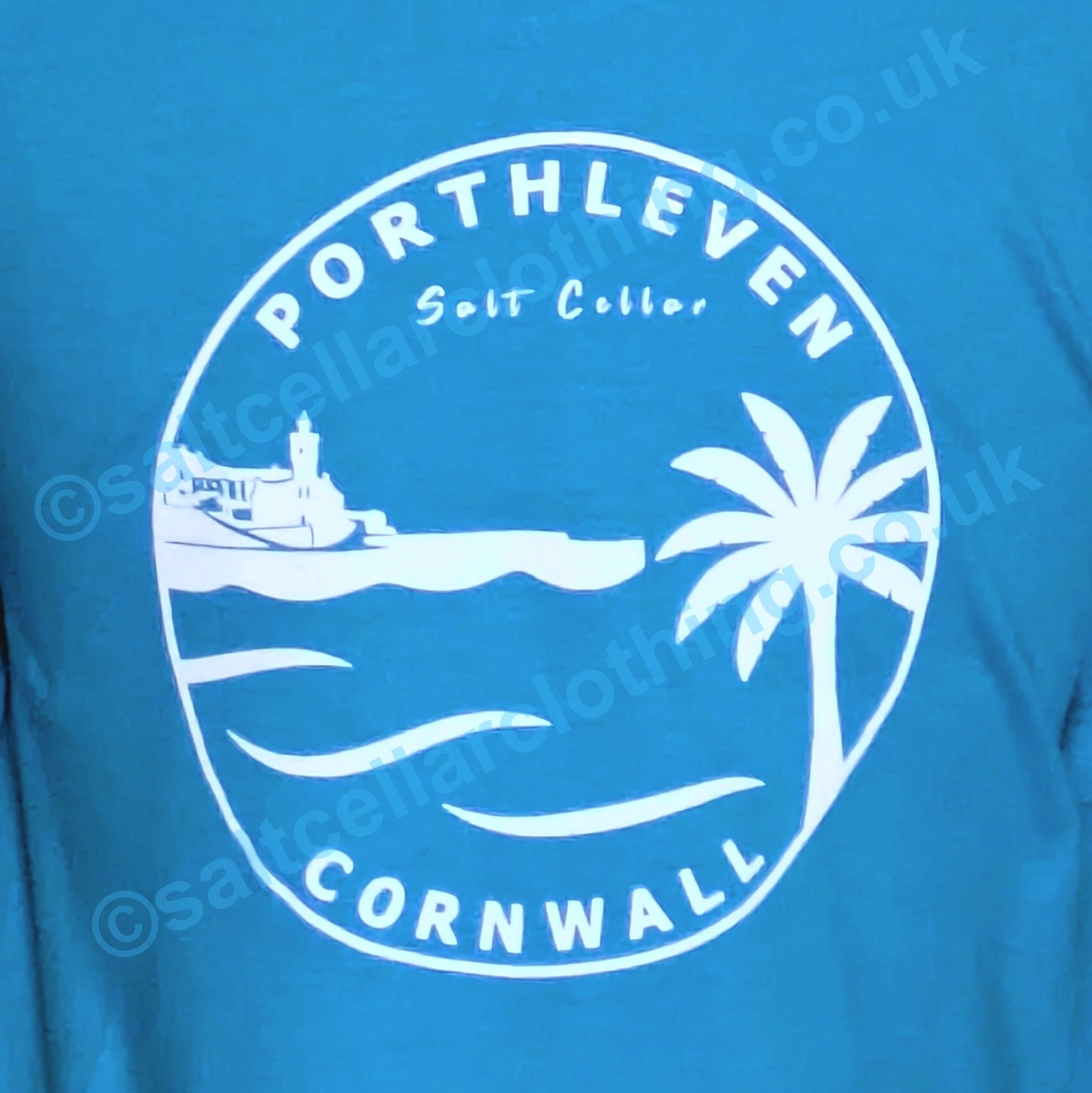 Blue kids t-shirt with white Porthleven, Cornwall graphic design featuring a harbour, clocktower and palm tree.