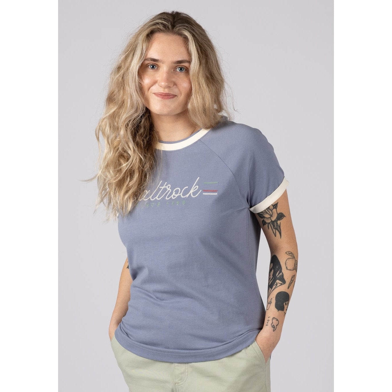 Front view of a woman wearing a Saltrock blue short sleeve Links t-shirt with logo on the chest on a plain background