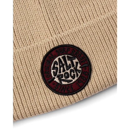 Beige knitted beanie with a Salt Rock logo patch on a white background