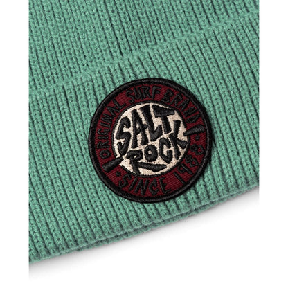 Close-up of a turquoise green knitted beanie with a turn-up hem and round 'Salt Rock' logo on a white background