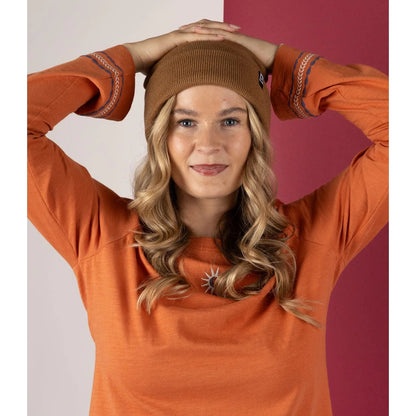 Woman wearing an orange sweater and brown Saltrock beanie against a two-tone background